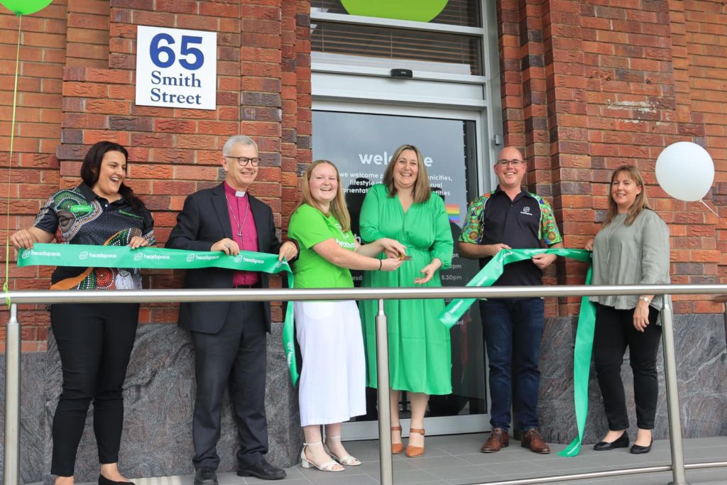 A team from Samaritans stand on a balcony after officially cutting a ribbon for the opening of a building