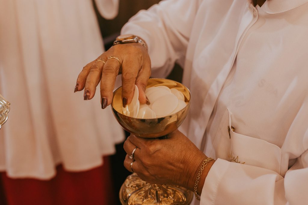 A half body picture of a woman picking communion bread from a cup