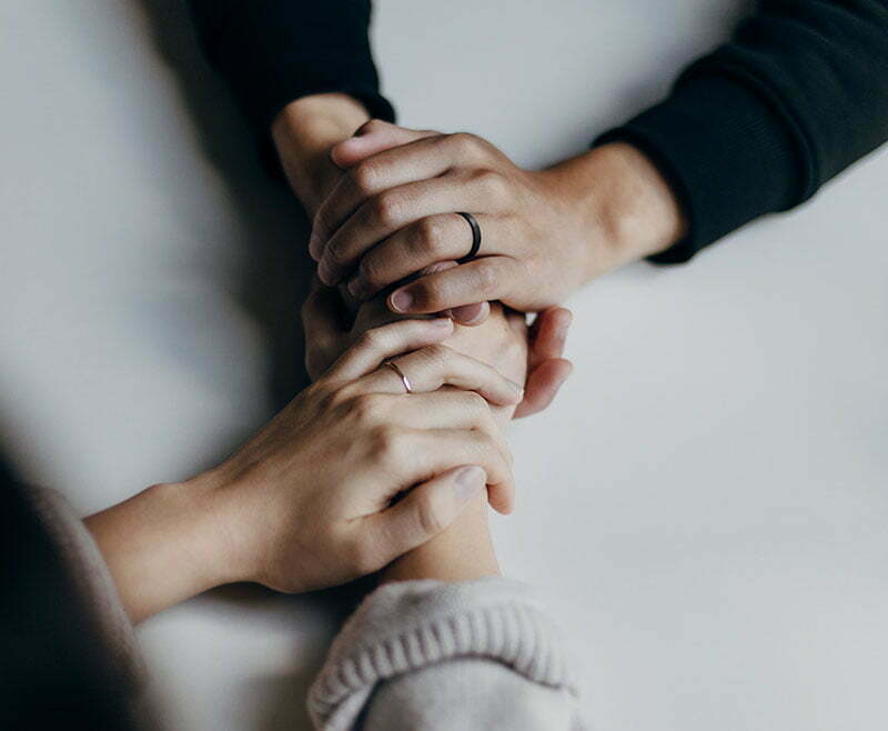 A shot of two people with interlocked hands
