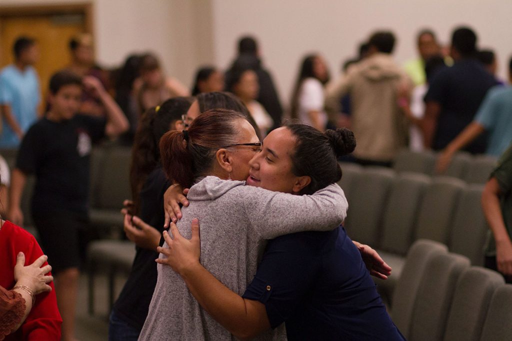 Two community members of a church embracing in a hug