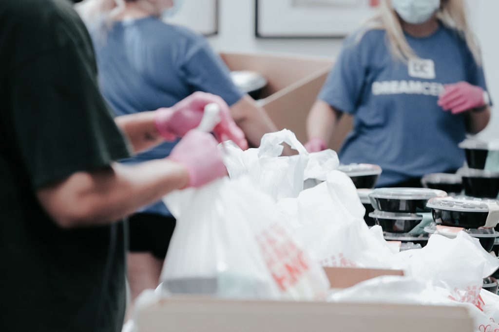 A group of volunteers pack grocery bags with food